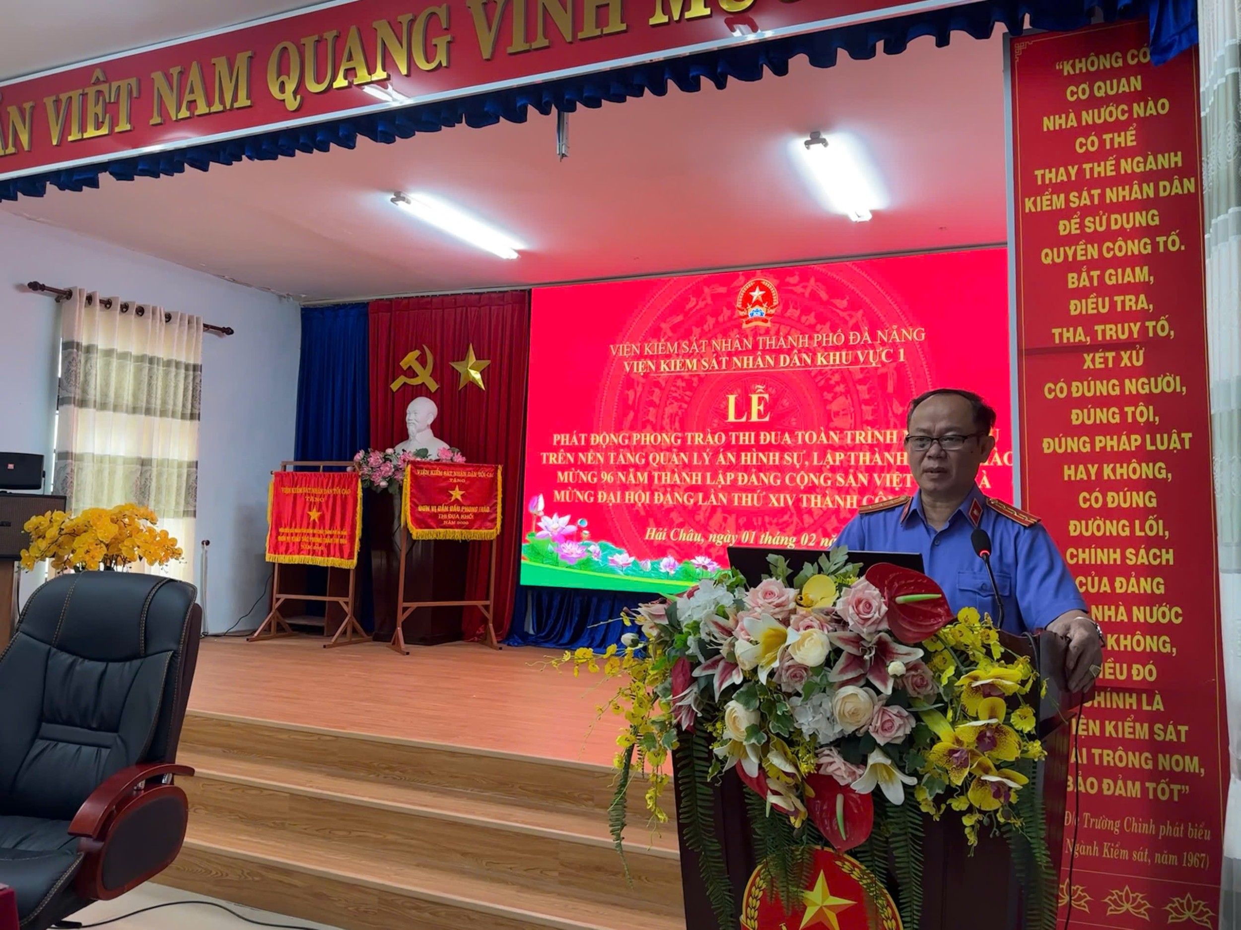 ''A person standing in front of a podium with flowers

Description automatically generated''